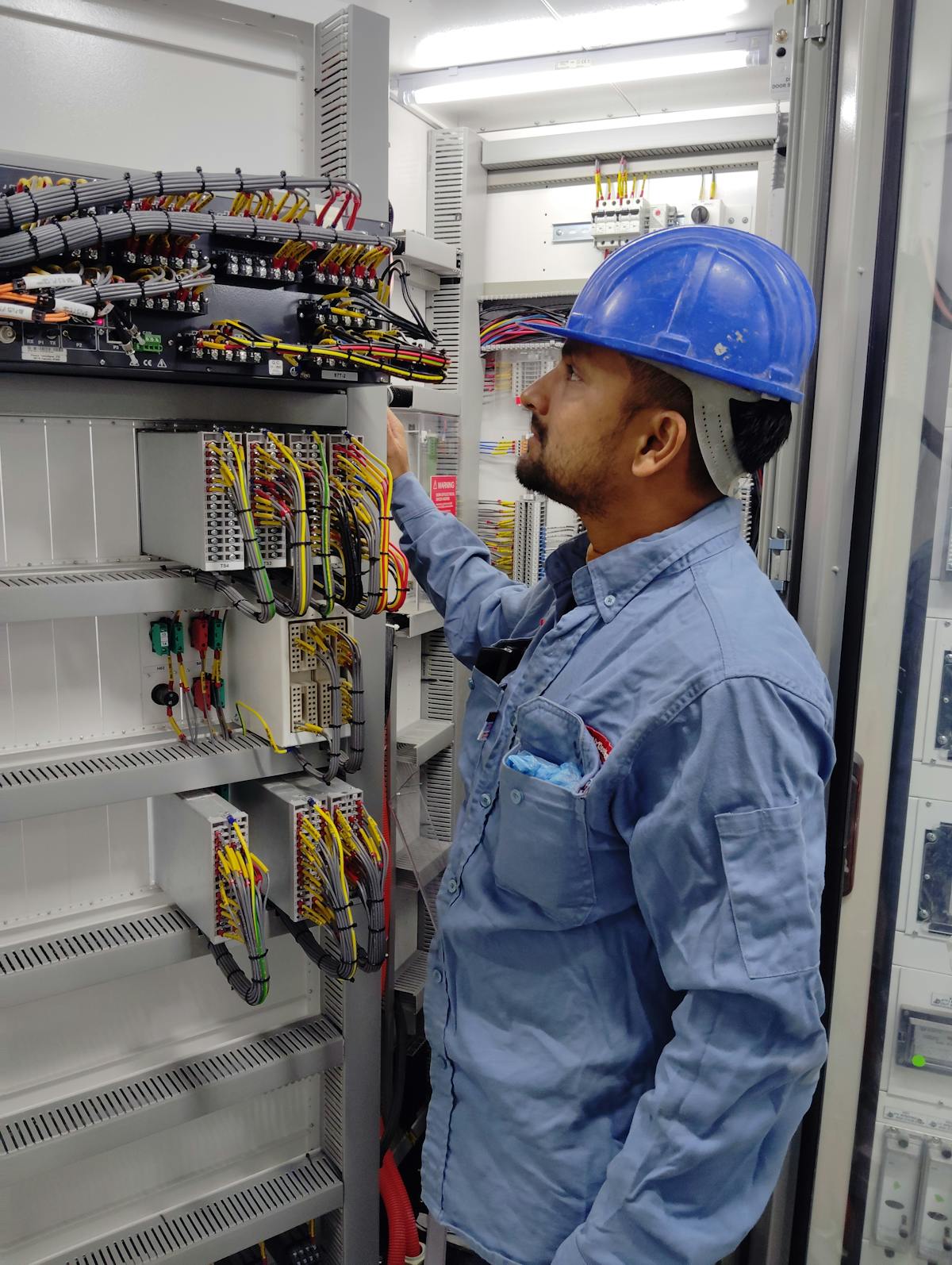 Electrician wiring a consumer unit with insulated tools