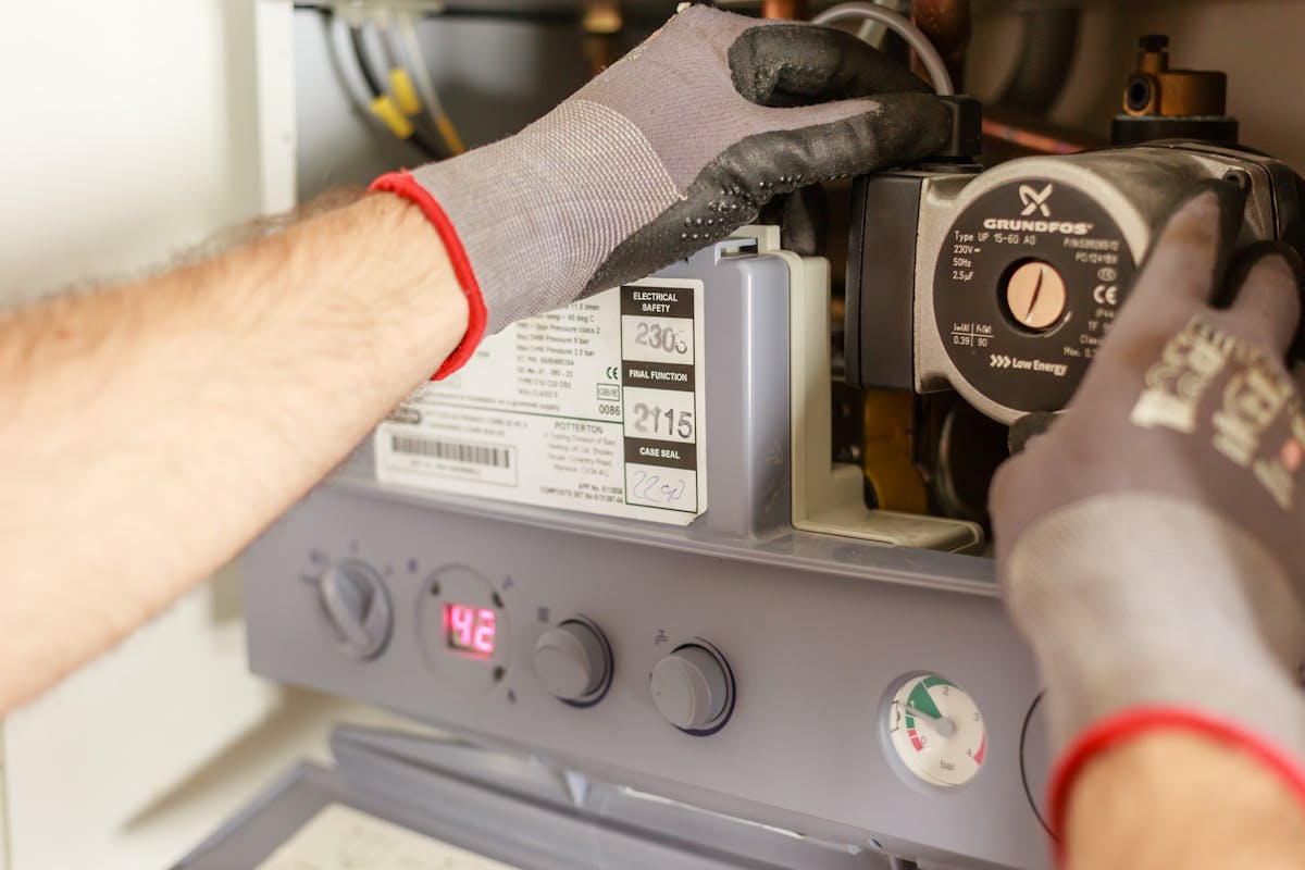 Engineer servicing a wall-mounted boiler with diagnostic tools